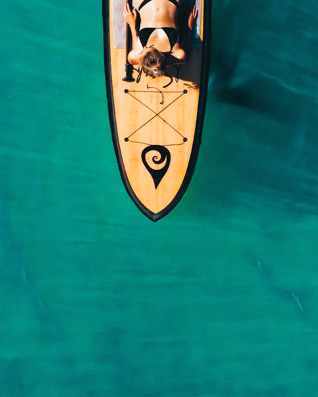 woman laying on paddle board
